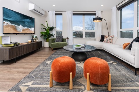 A living room with a large painting of a beach scene on the wall.